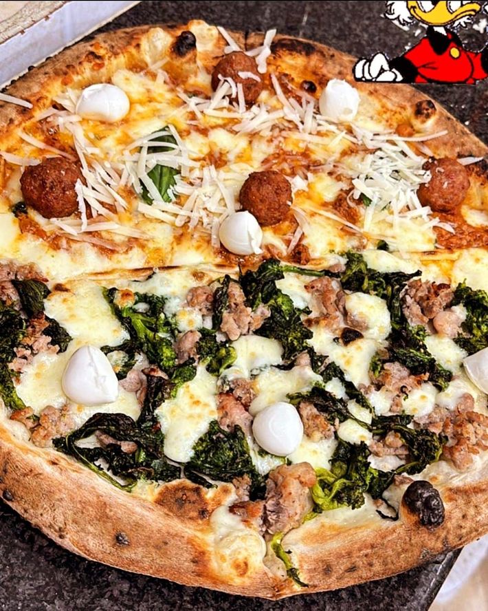 Una pizza con molti condimenti è seduta su un tavolo.