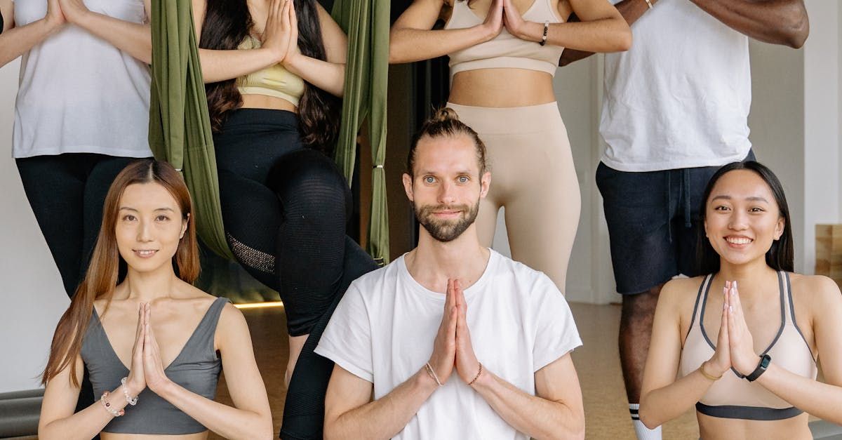 A group of people are doing yoga together in a gym.