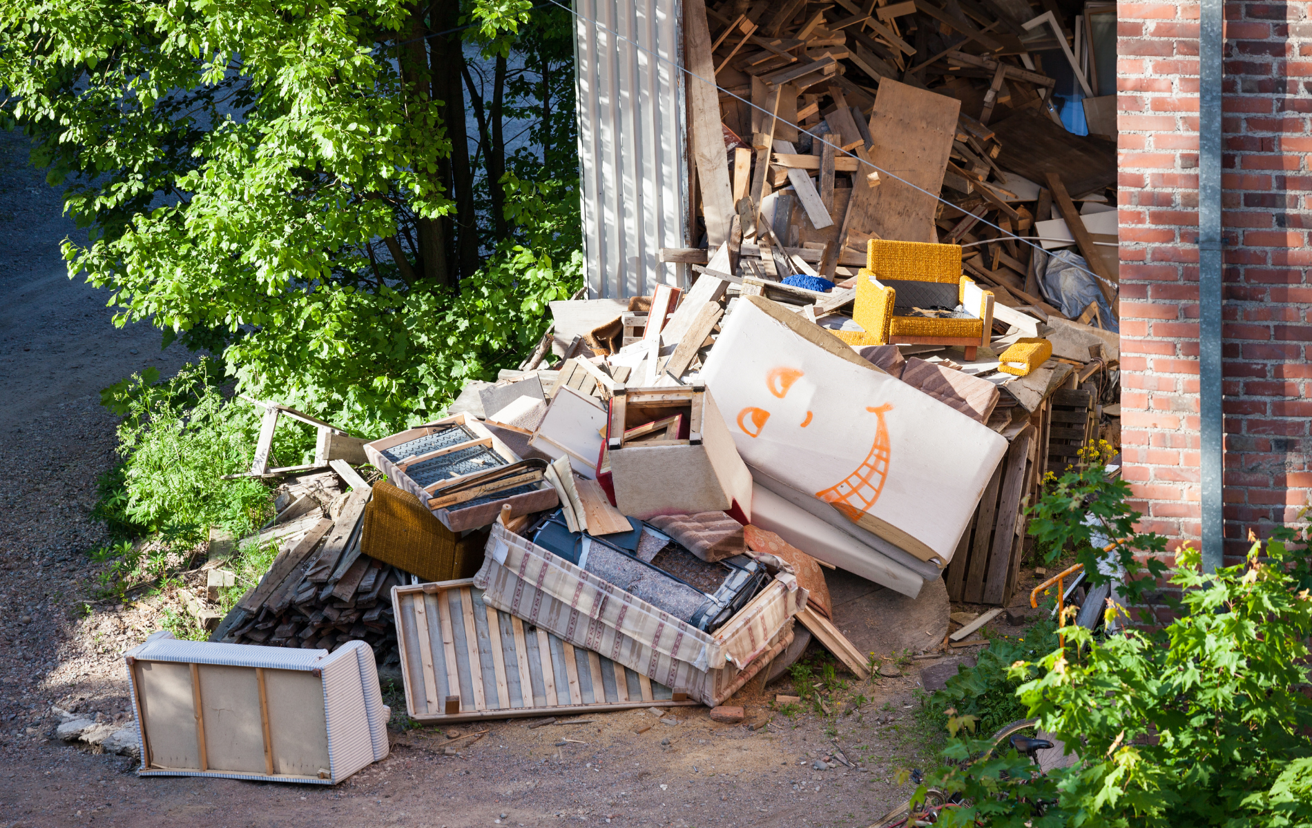 A pile of trash is sitting in front of a brick building.