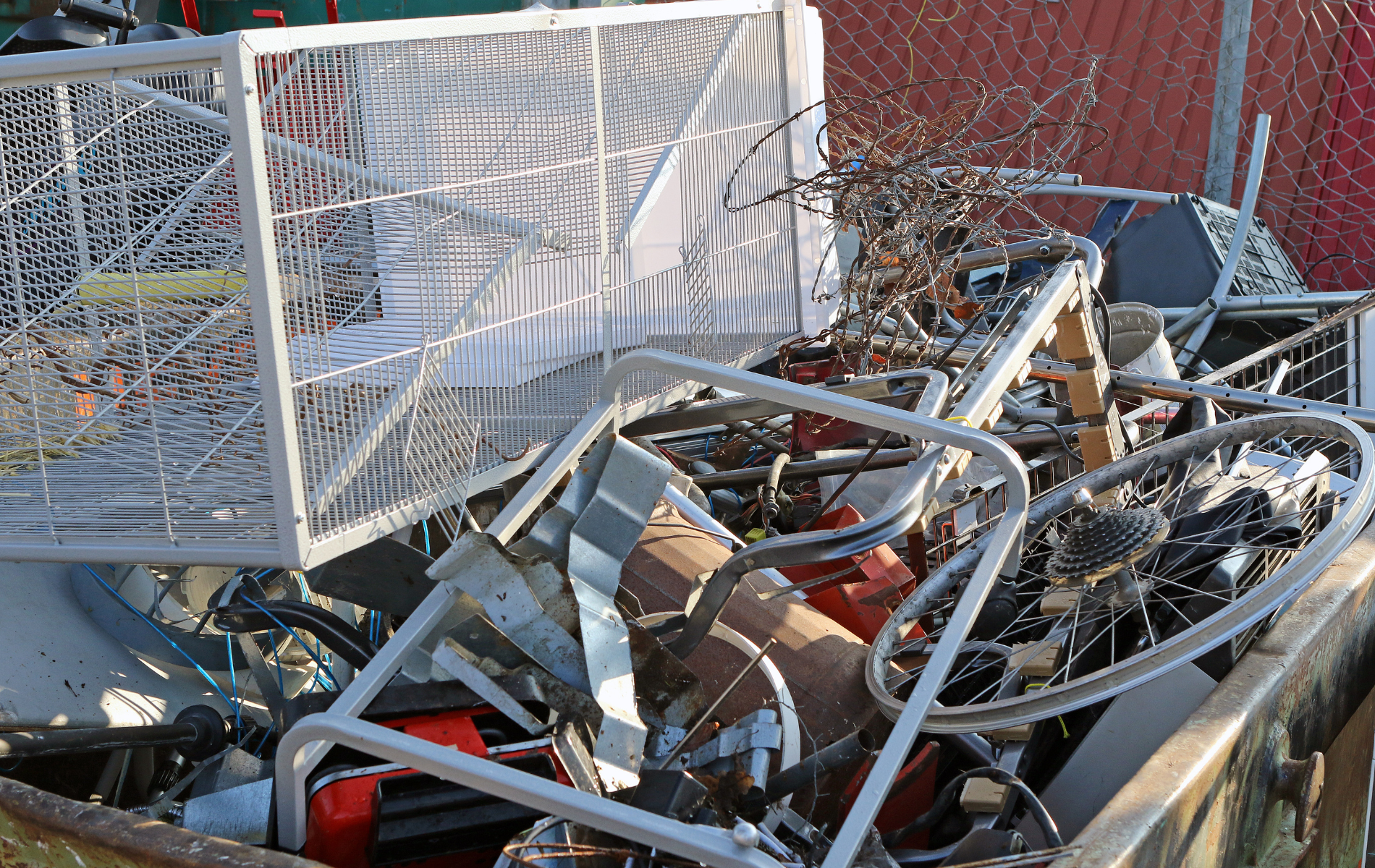 A pile of scrap metal is sitting in a dumpster.