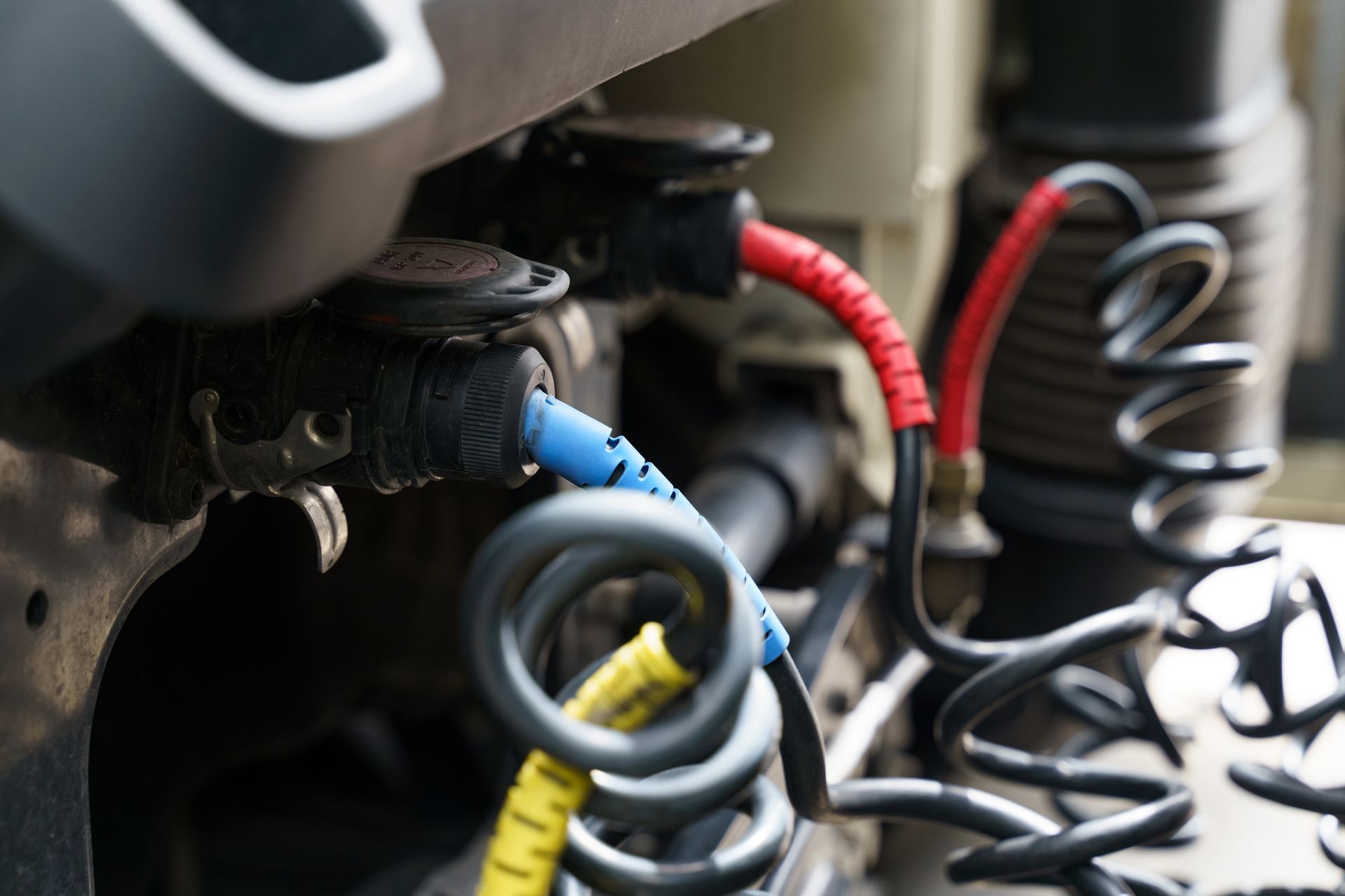Connecting pneumatic and electrical hoses and cables to a truck semi-trailer.