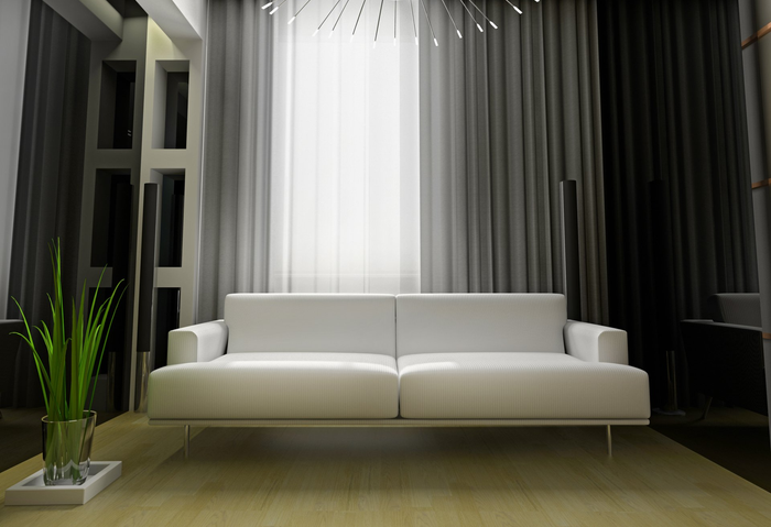 Stylish white couch in loungeroom with grey curtains opened over white sheers.