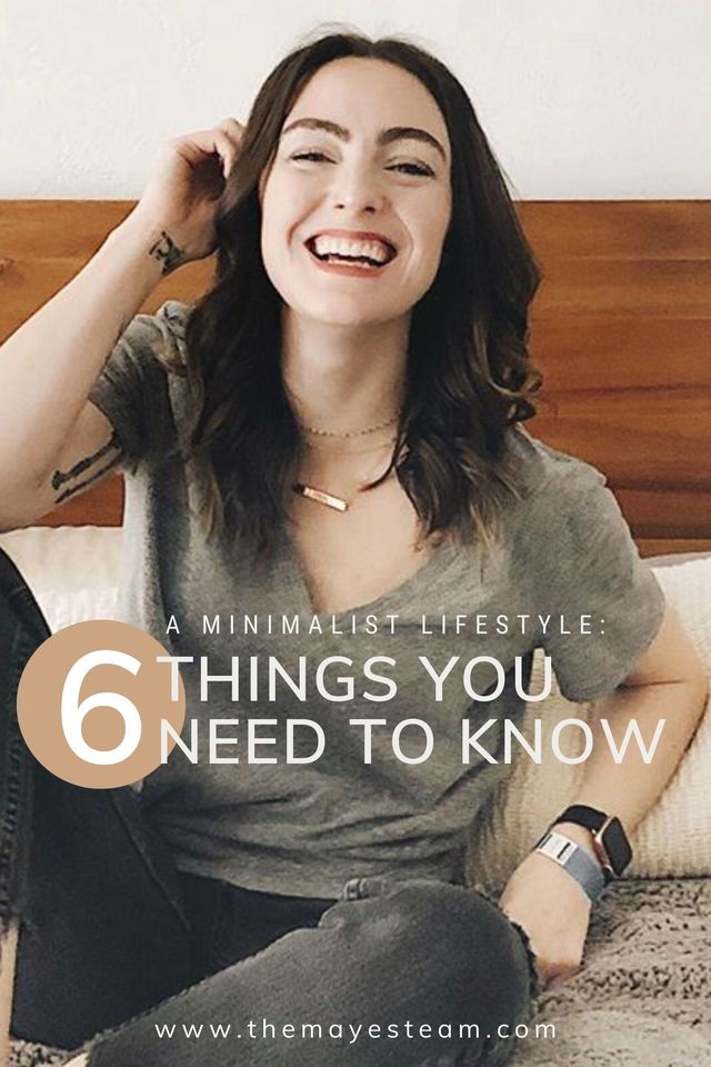 Debbie Mayes of The Mayes Team smiles while sitting on her bed. Image overlaid with text that reads A Minimalist Lifestyle: 6 Things You Need to Know.