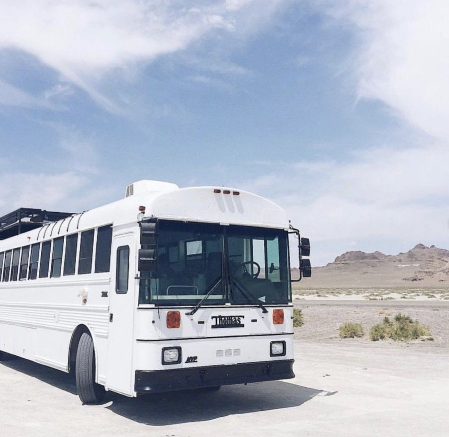The Mayes Team skoolie parked in a desert as an example of how to become a minimalist.