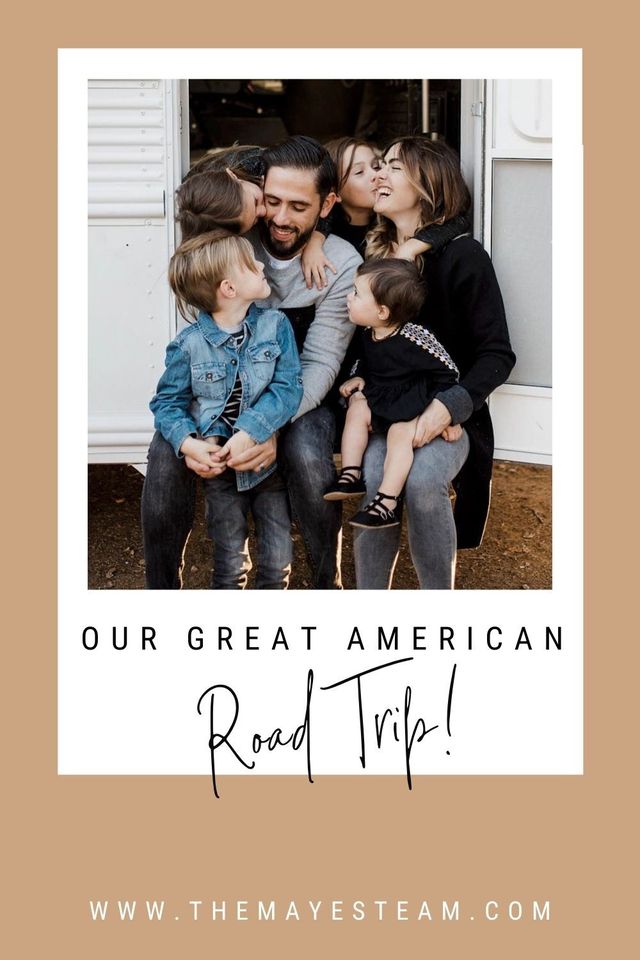 Debbie and Gabriel Mayes sit on the step of their skoolie with their kids as they smile about their great American road trip!