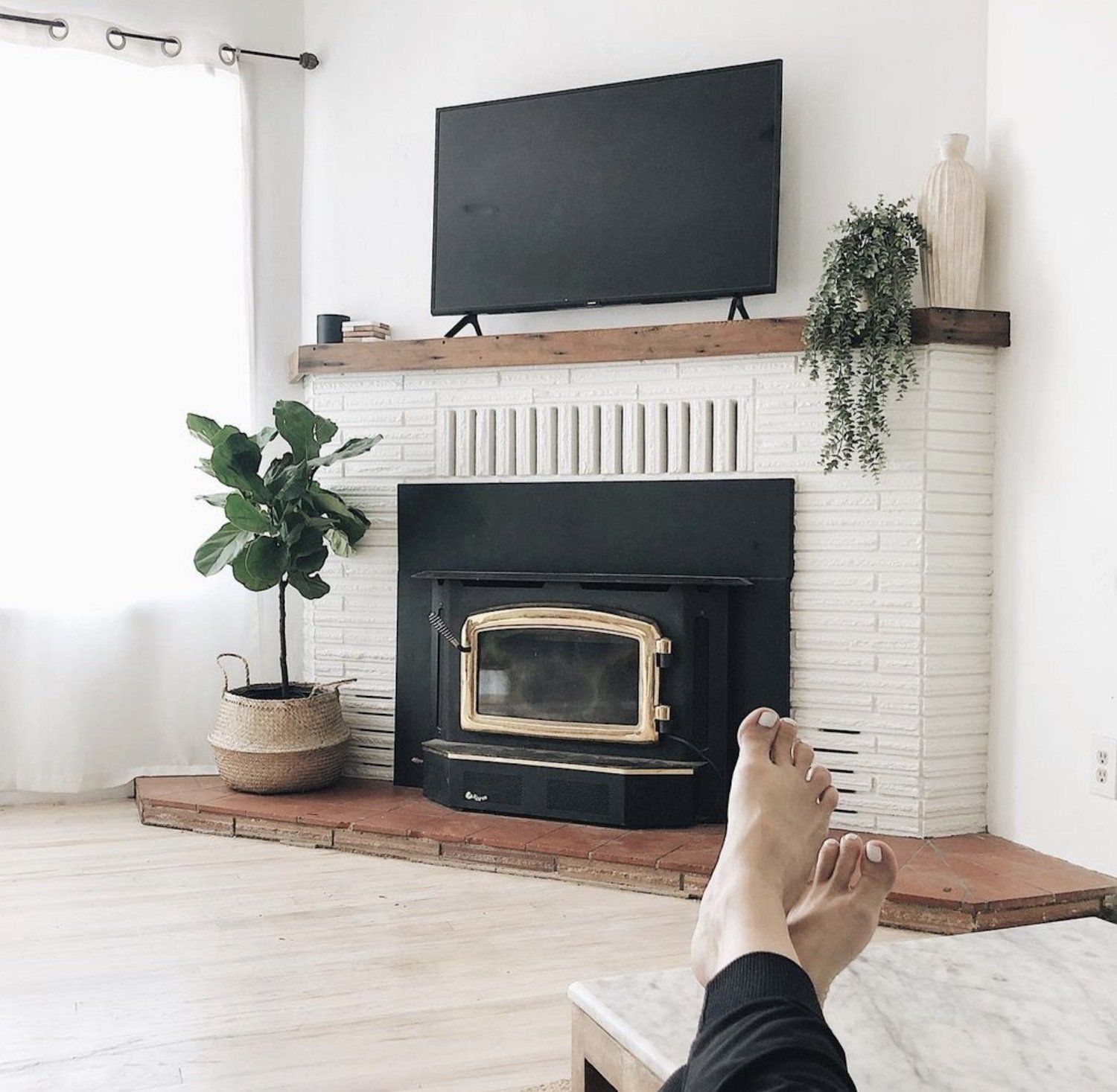 Debbie Mayes' feet rest in front of a fireplace after she shared on how to become a minimalist
