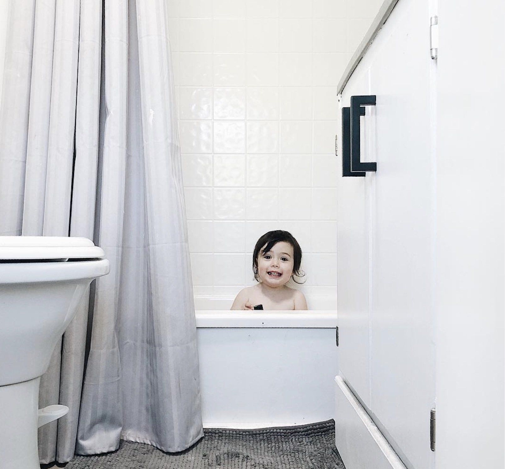 One of the kids from the Maisey family sits in the bathtub that's part of the skoolie interior.