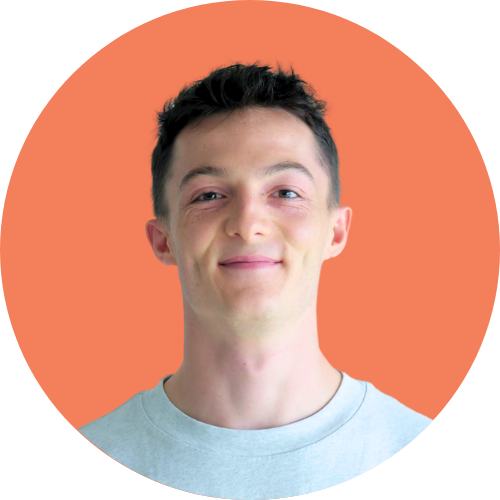 Homme aux cheveux noirs courts souriant, encadré dans un cercle pêche, portant un t-shirt bleu clair.