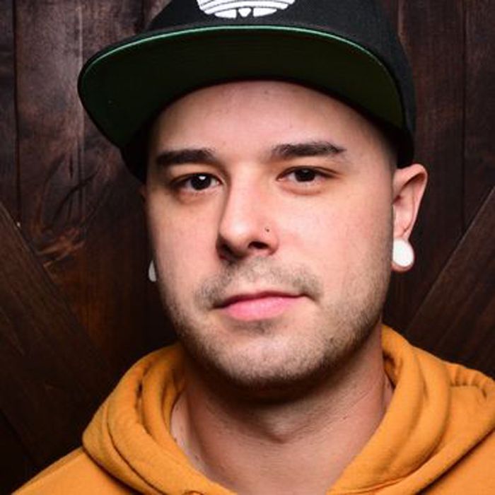 A man wearing a yellow hoodie and a black hat