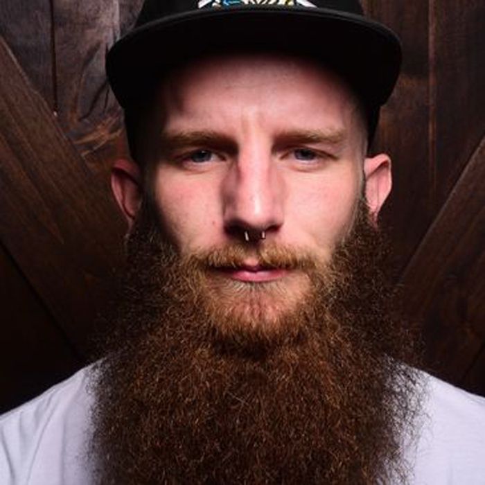 A man with a beard wearing a hat and a nose ring.