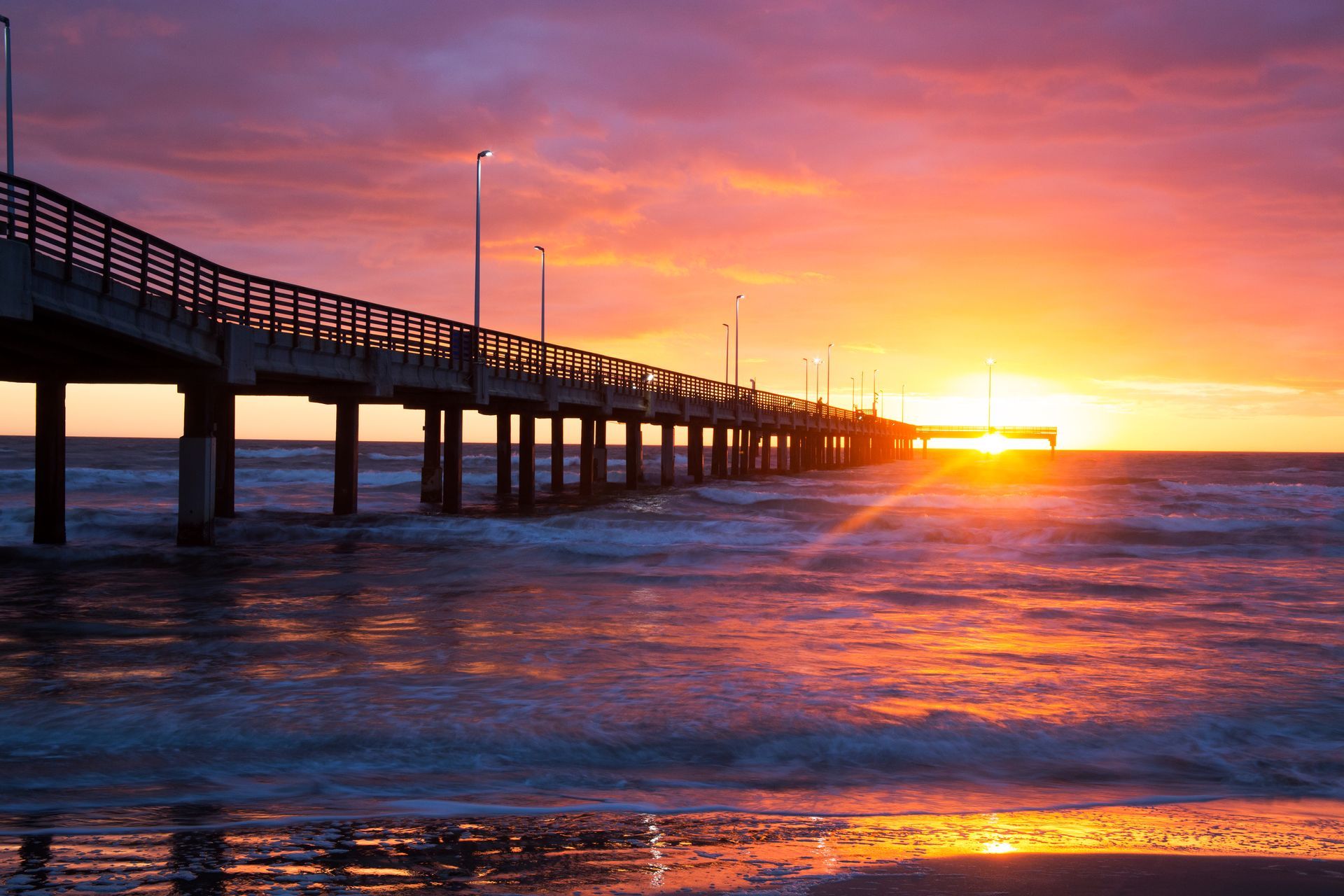 A pier overlooking the ocean at sunset.