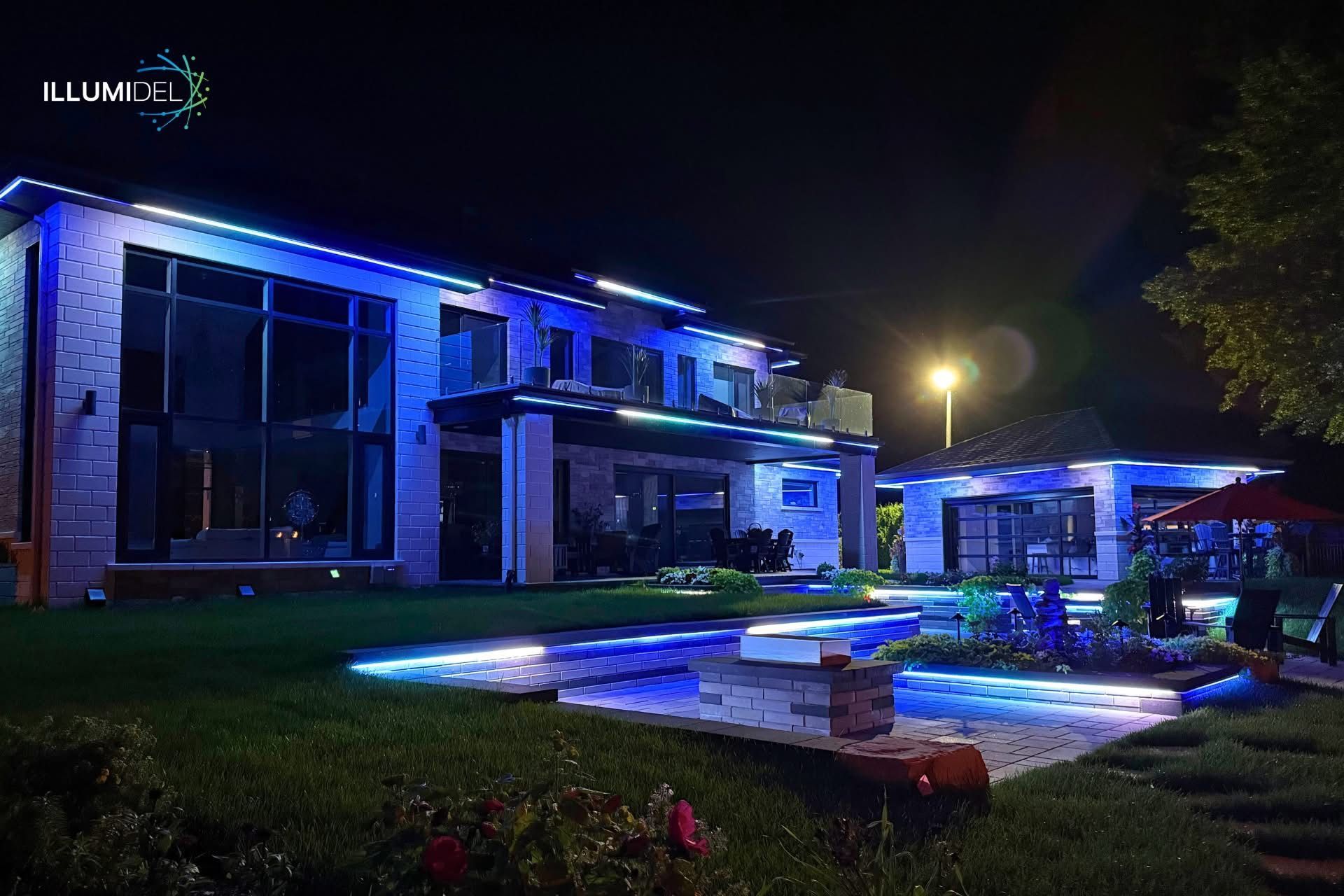 Modern house illuminated with blue lights at night, highlighting the pool and exterior.