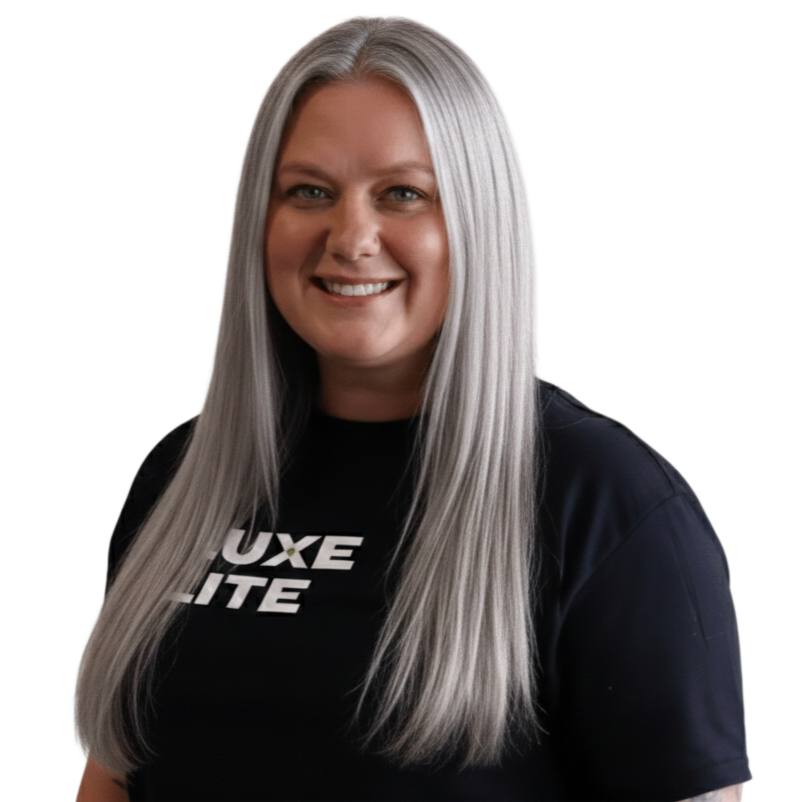 Woman with long silver hair smiling, wearing a black t-shirt with