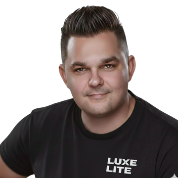 Man wearing a black t-shirt with “Luxe Lite” logo, looking at the viewer.