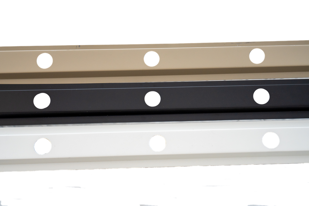 Three horizontally aligned strips of material: tan, black, and white. Each has regularly spaced circular holes.