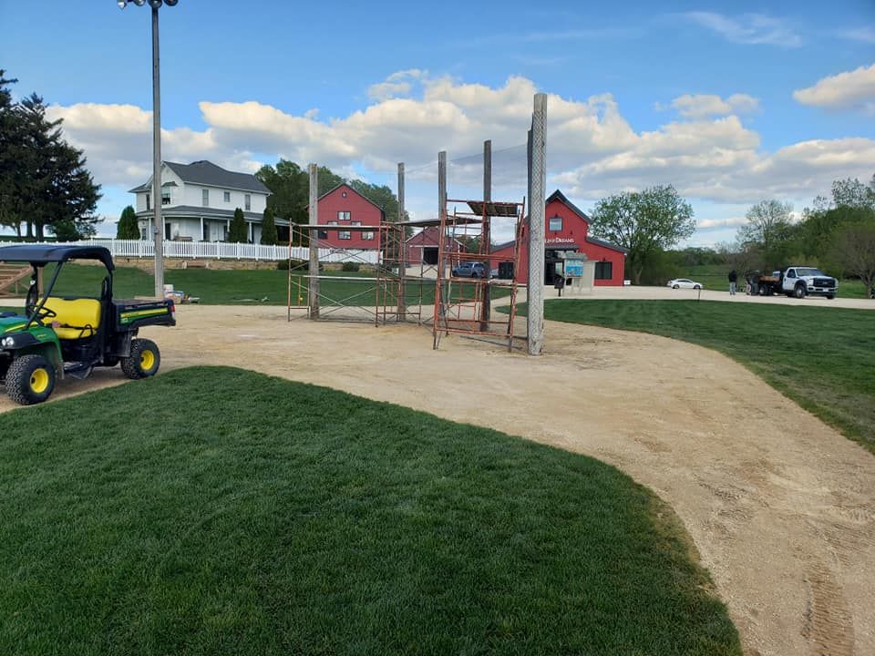 A john deere gator is parked in front of a playground in a park.