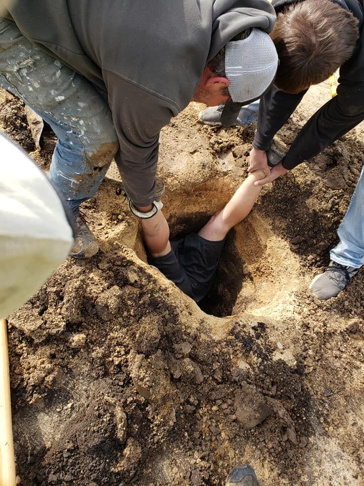 A group of people are digging a hole in the ground.