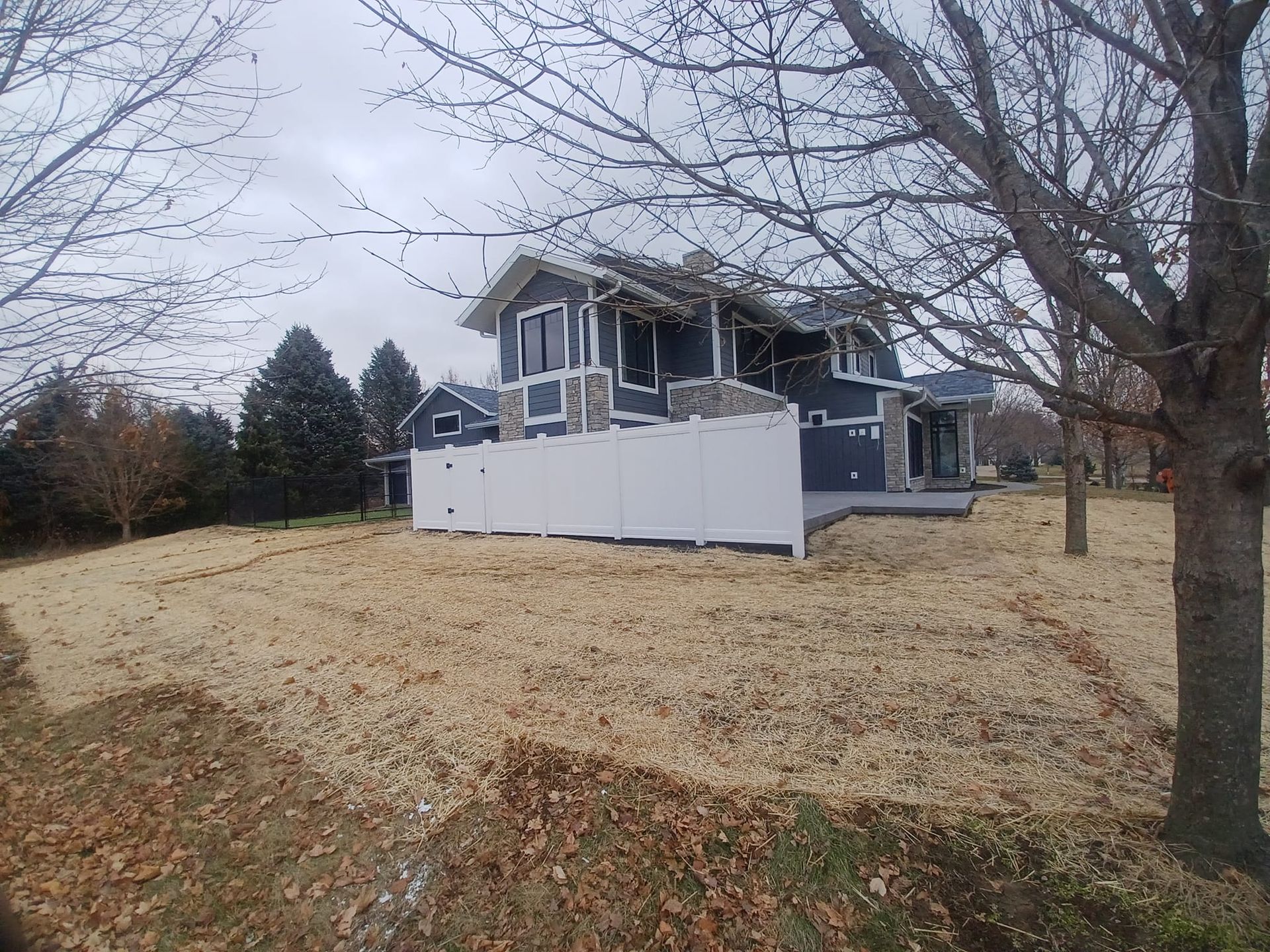 A large house with a white fence in front of it.