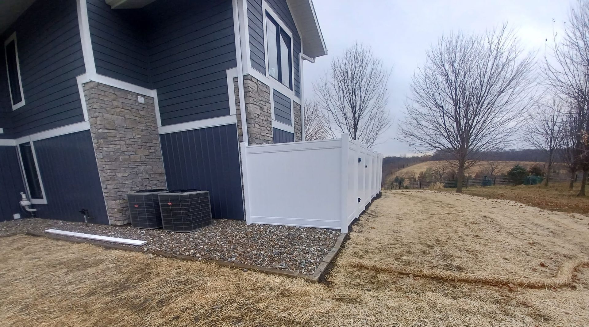 A blue house with a white fence in front of it