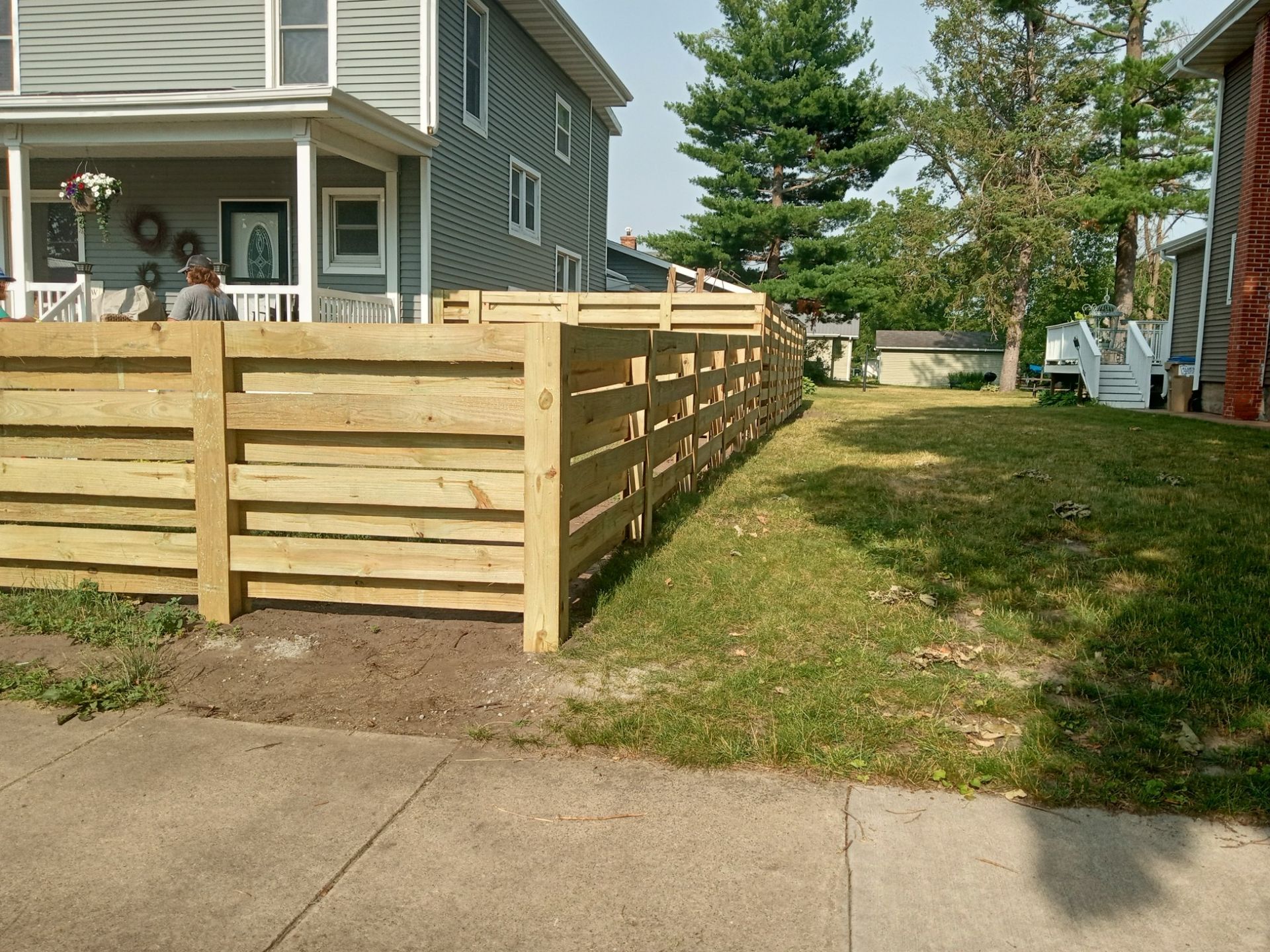 A wooden fence with a house in the background