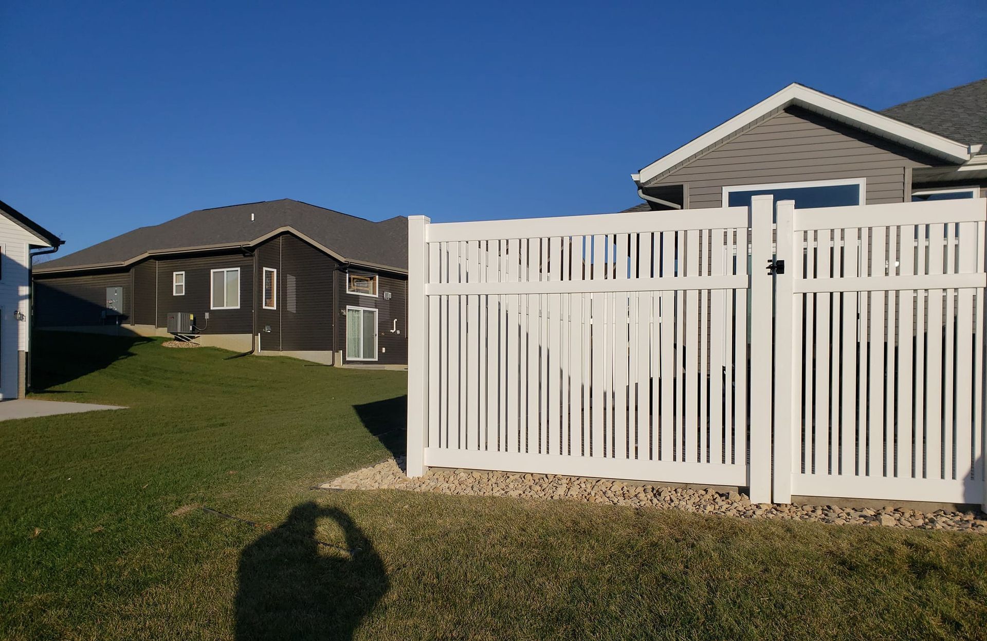 A white fence with a gate in front of a house