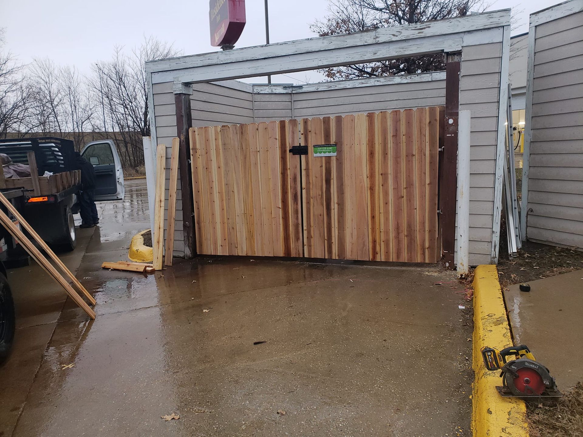 A wooden gate is being built in front of a building.