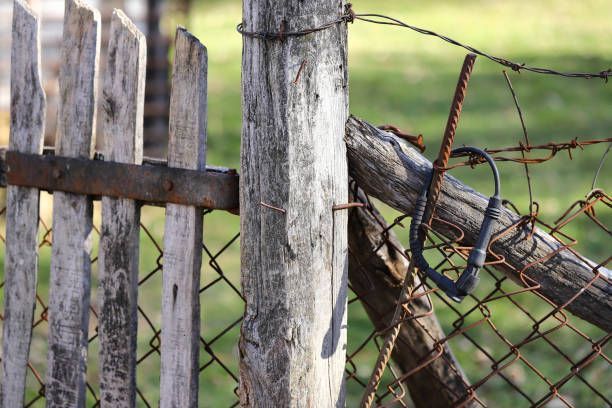 A wooden fence with a barbed wire fence behind it