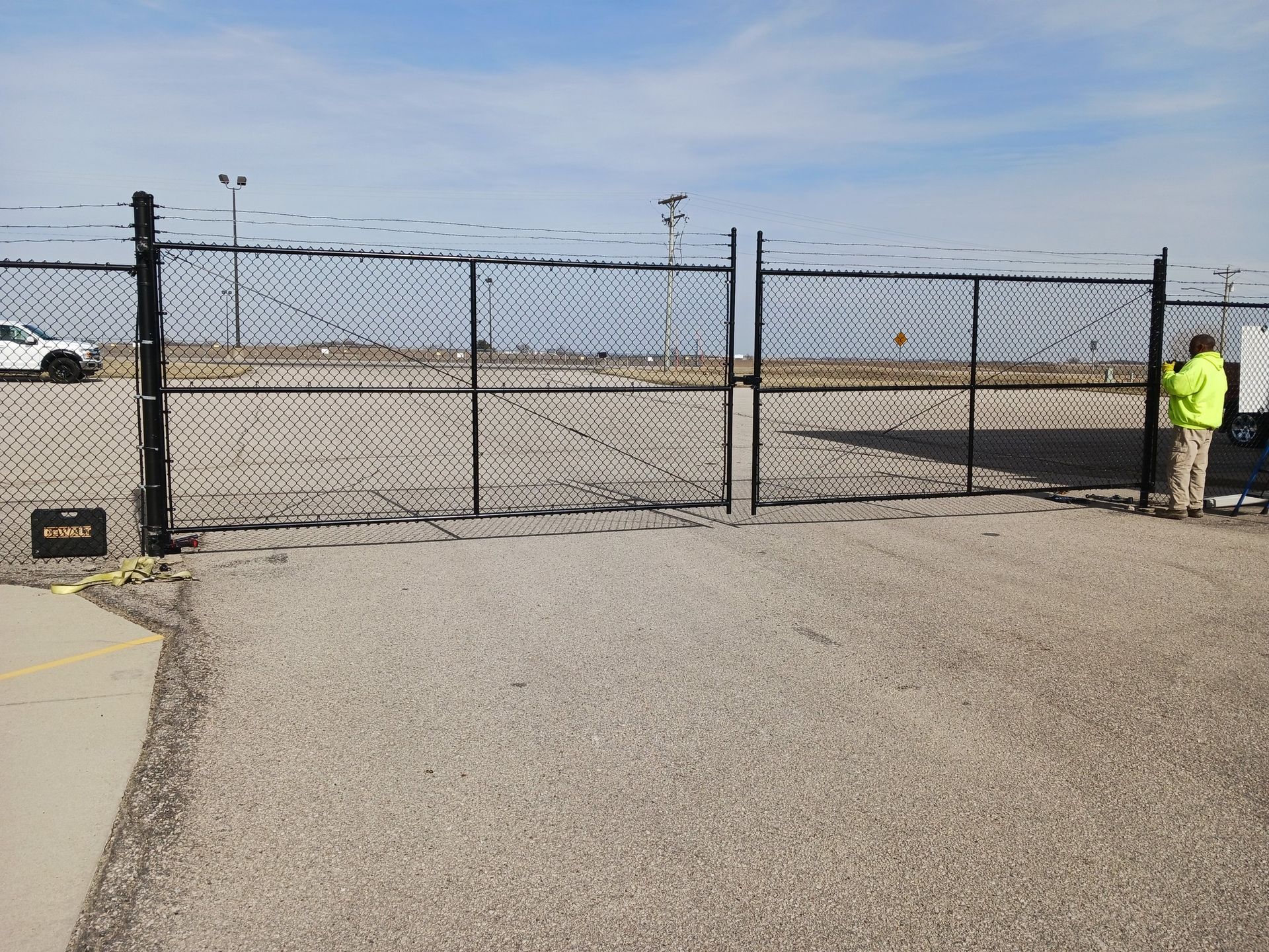 A man is standing in front of a chain link fence.