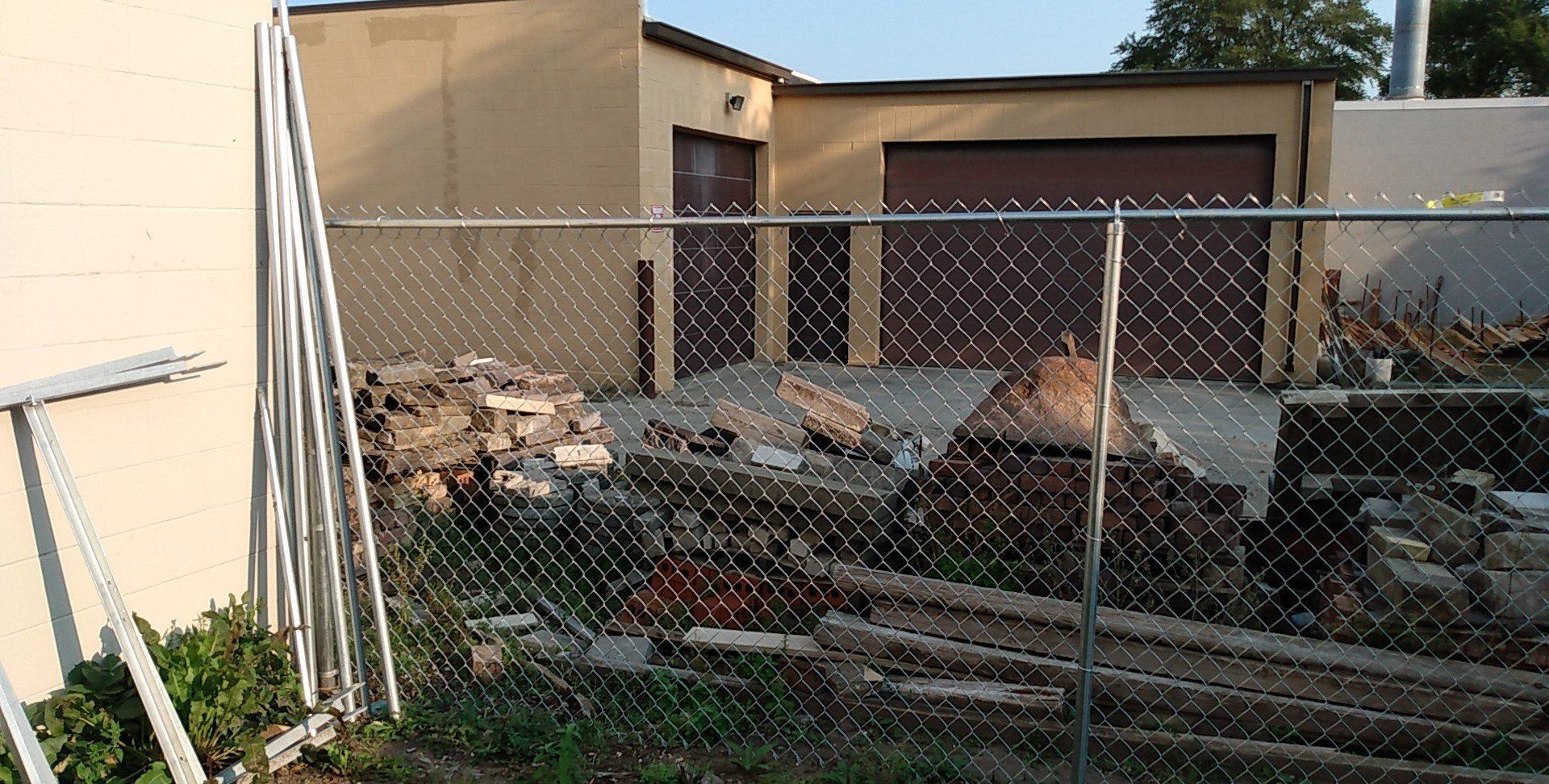 A chain link fence is in front of a garage