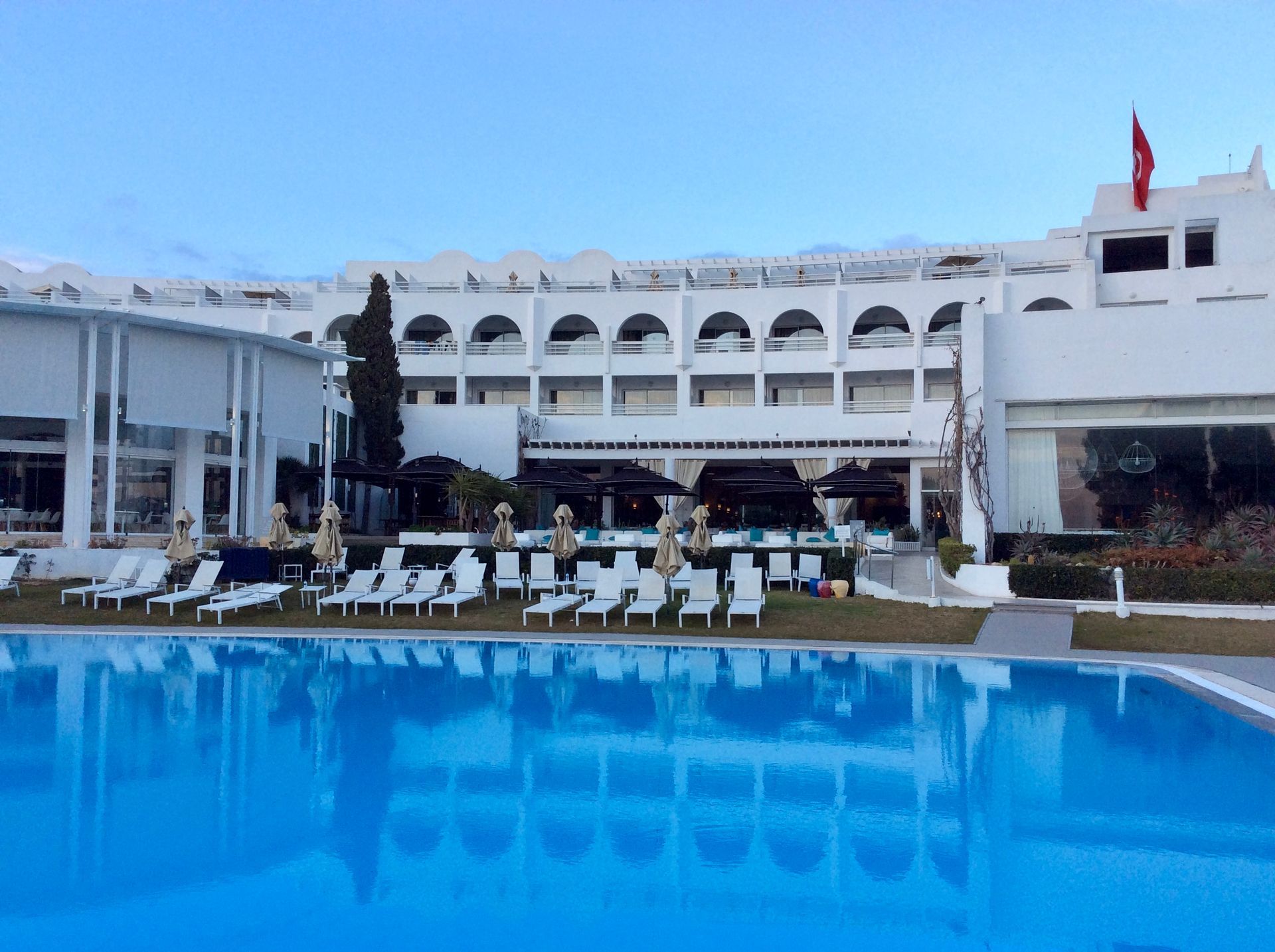 There is a large swimming pool in front of a 5 star hotel in Tunis.