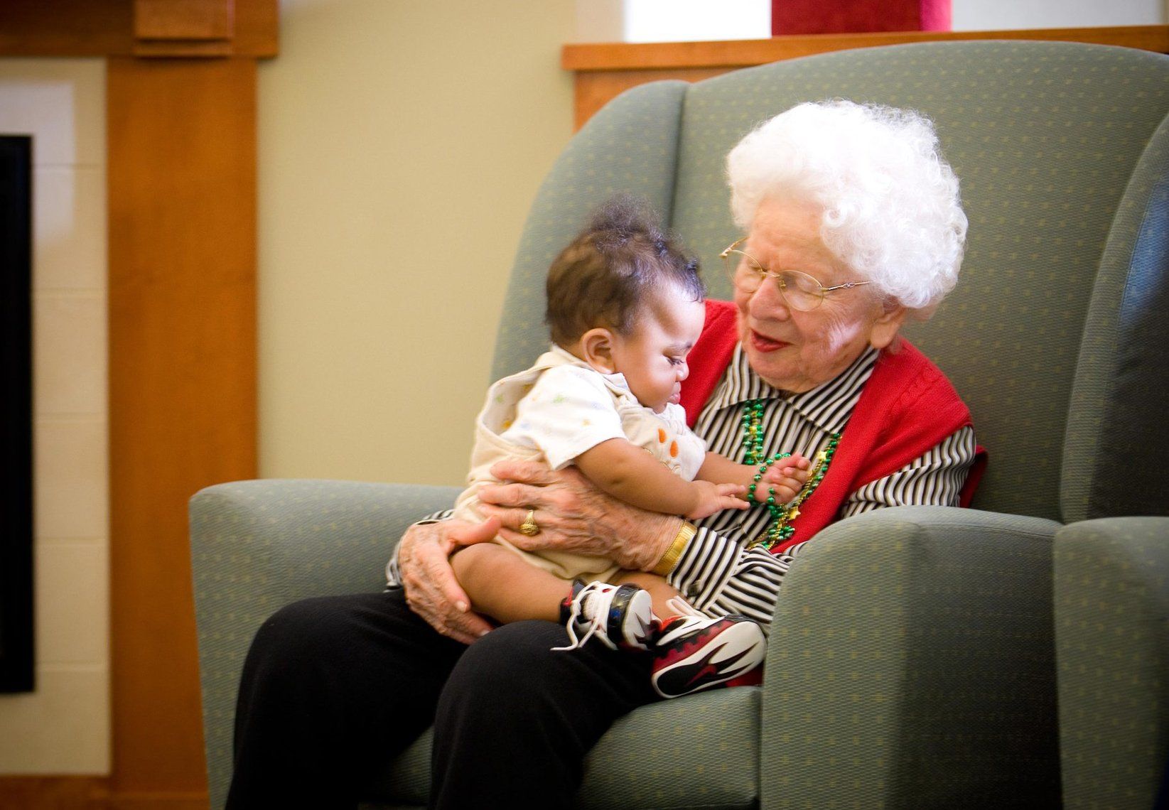Elder Care — Happy Elderly Woman Holding A Baby In Spring, MD