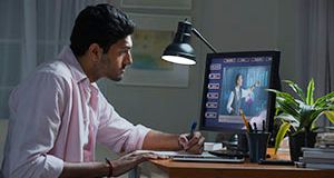 A man is sitting at a desk in front of a computer.