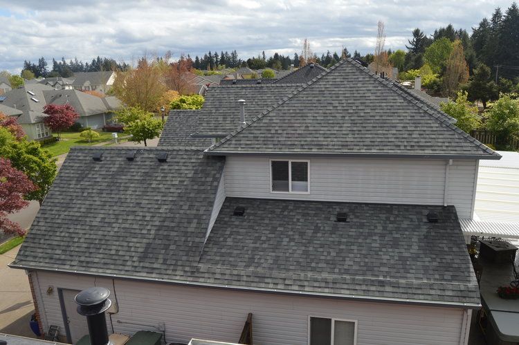 An aerial view of a house with a gray roof