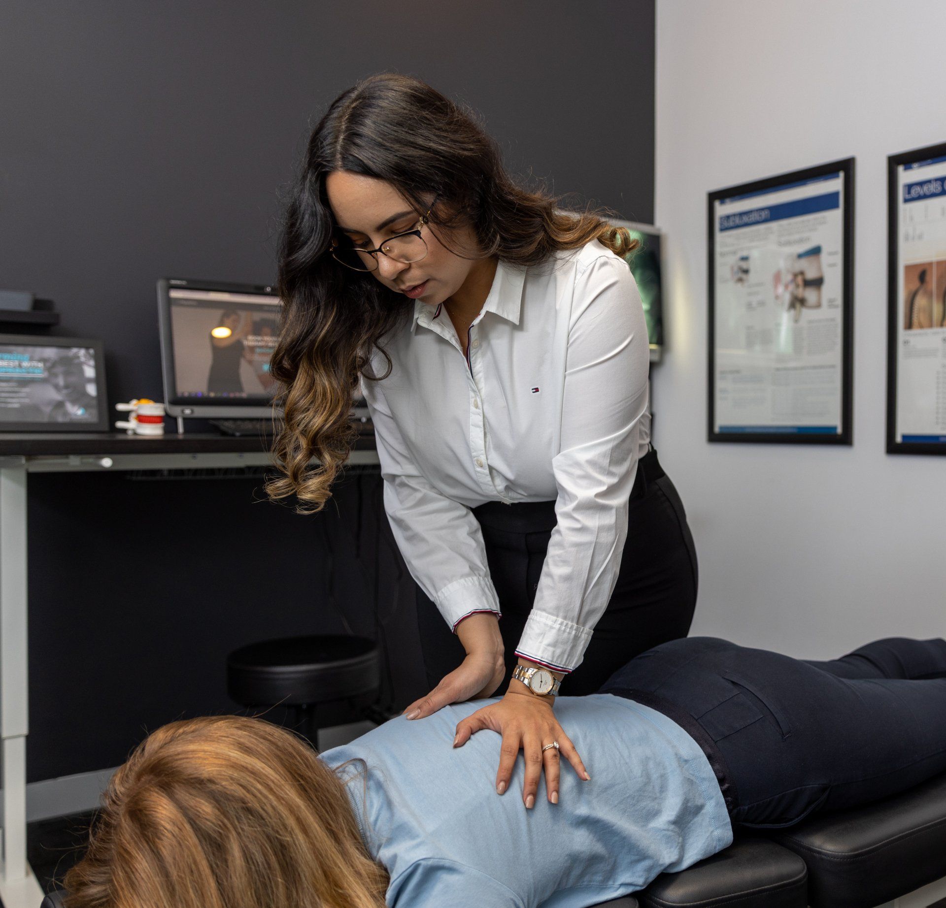 female chiropractor helping with back pain treatment