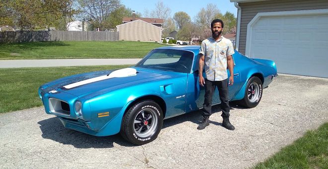 dmarcus spencer in front of his car