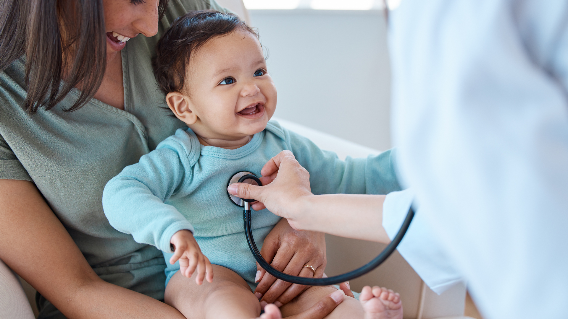 A baby is being examined by a doctor with a stethoscope.