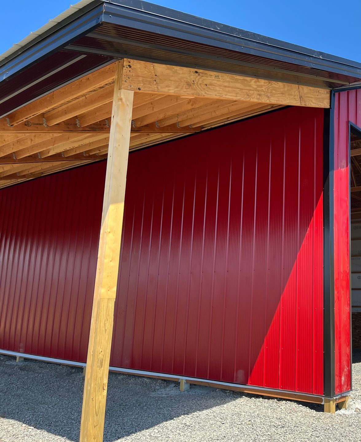 A red building with a wooden roof and a wooden post