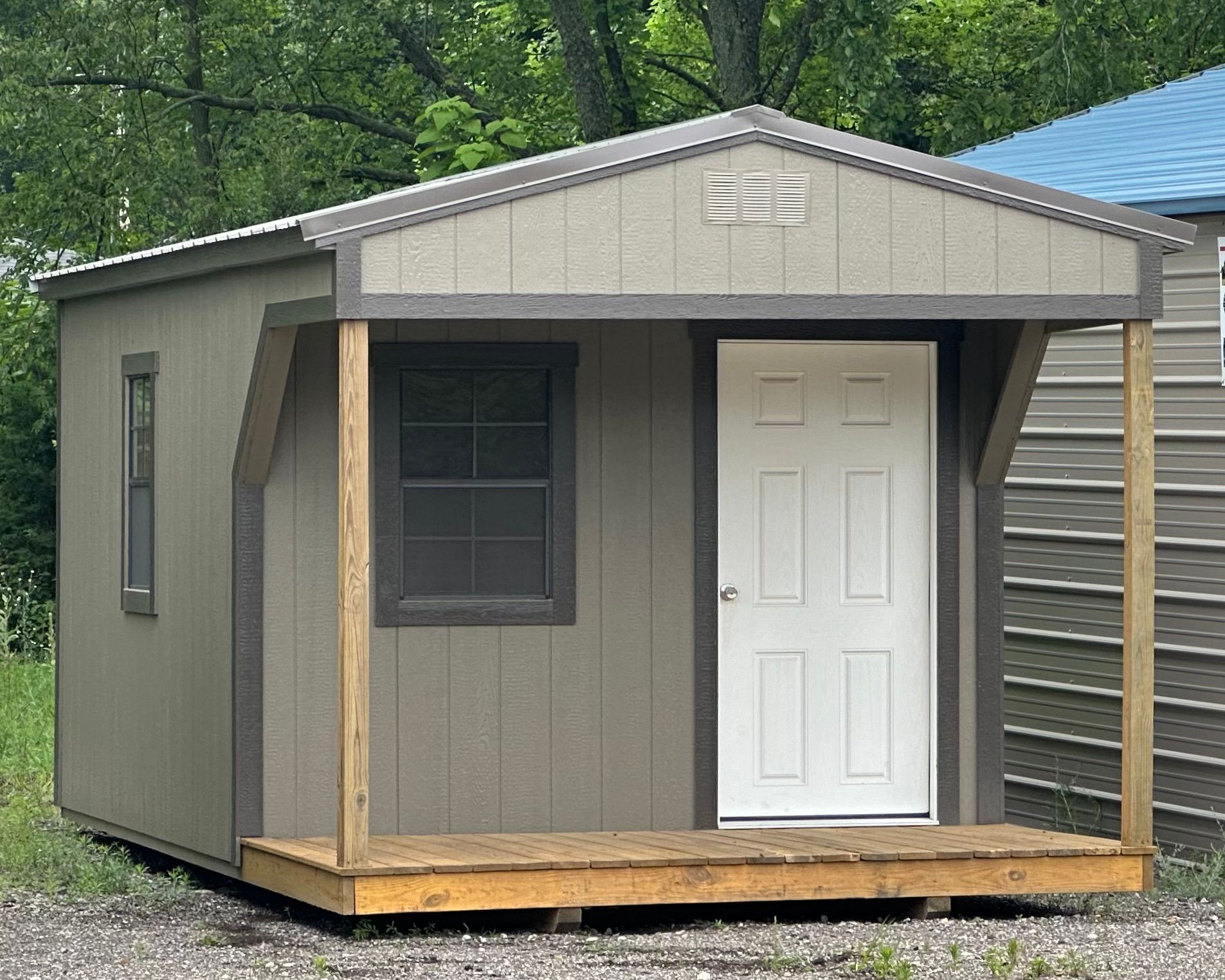 A small shed with a porch and a white door.