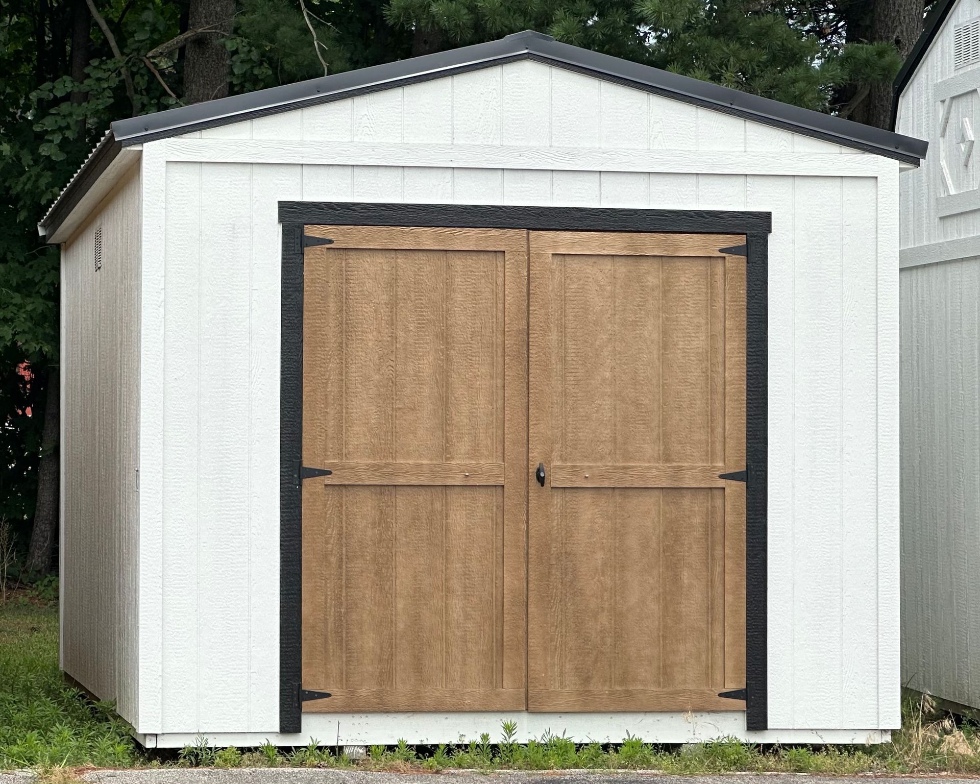 A white garage with wooden doors and a black trim
