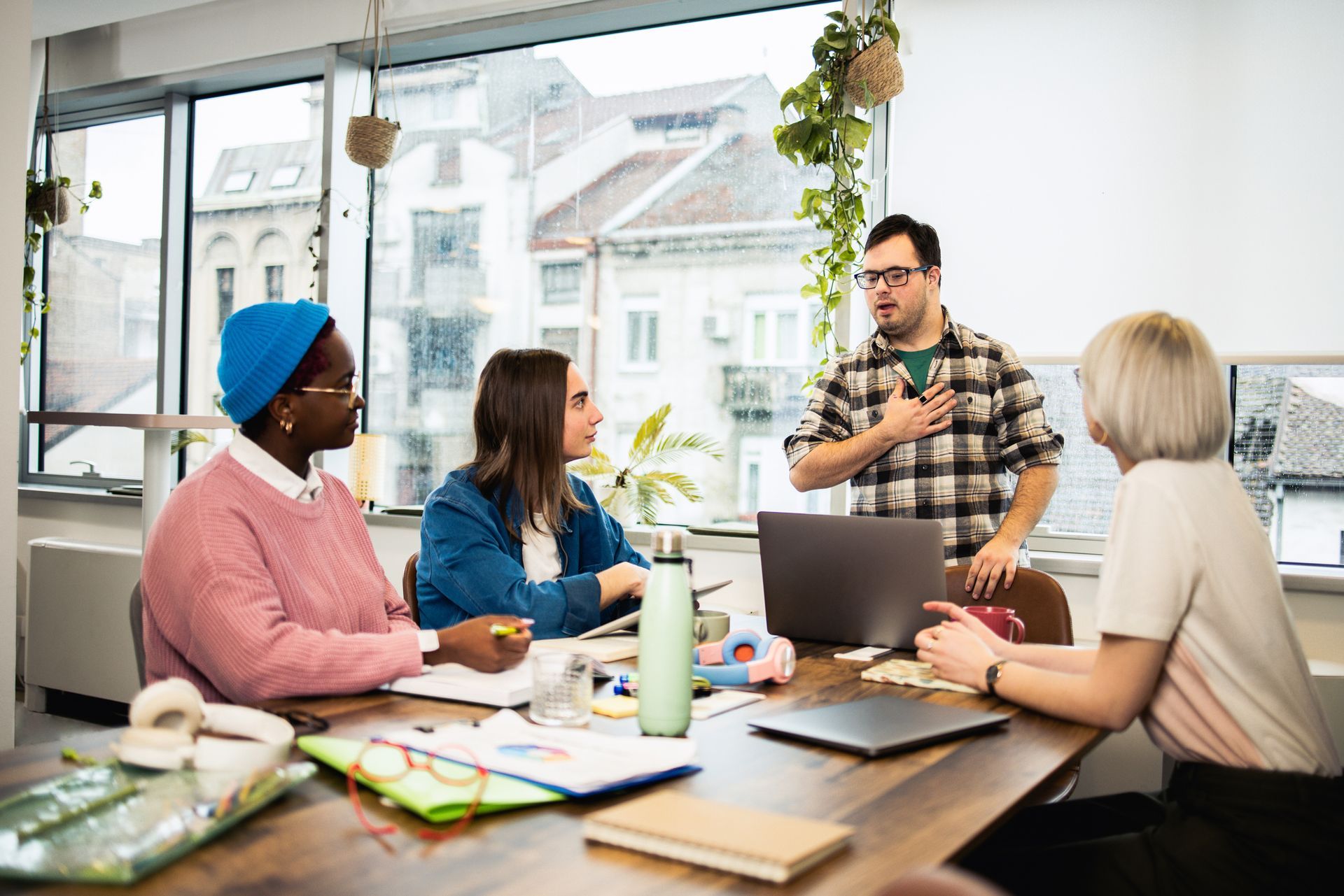 Un gruppo di persone è seduto attorno a un tavolo con i propri computer portatili.