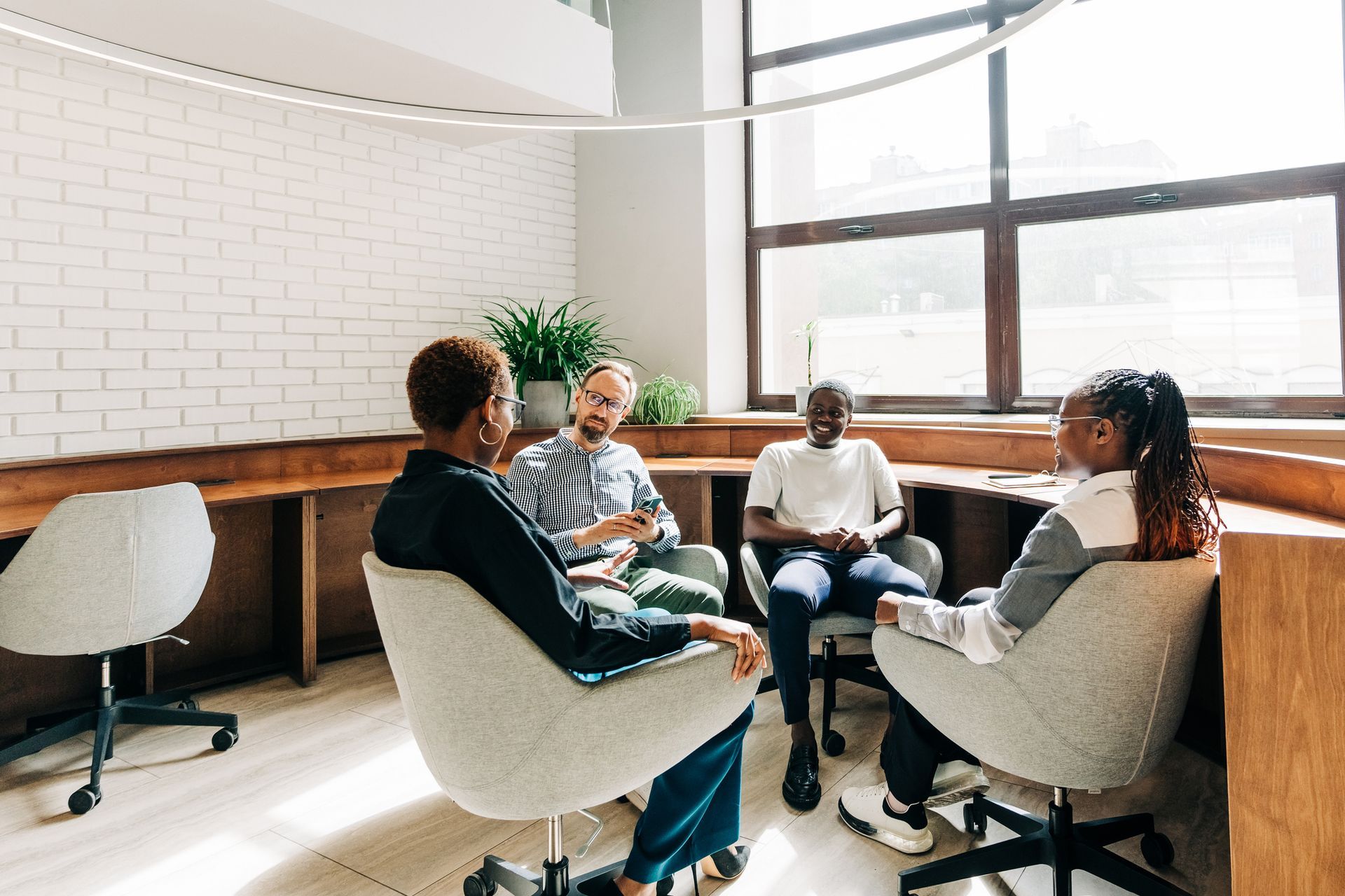 Un gruppo di persone è seduto su delle sedie in una stanza e sta conversando.