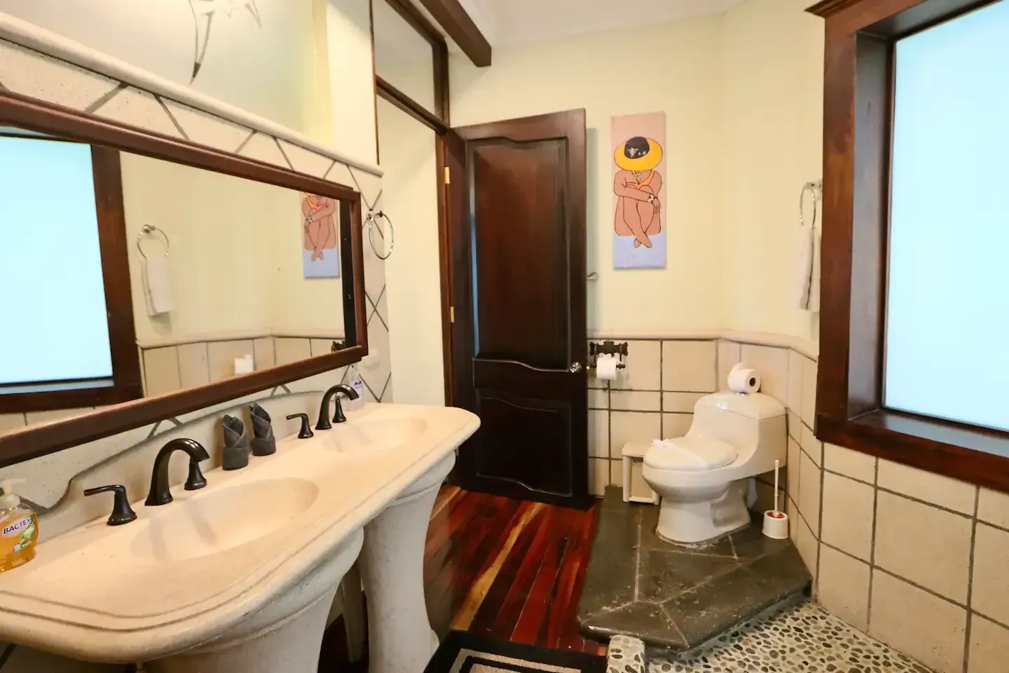 A bathroom with two sinks and a toilet