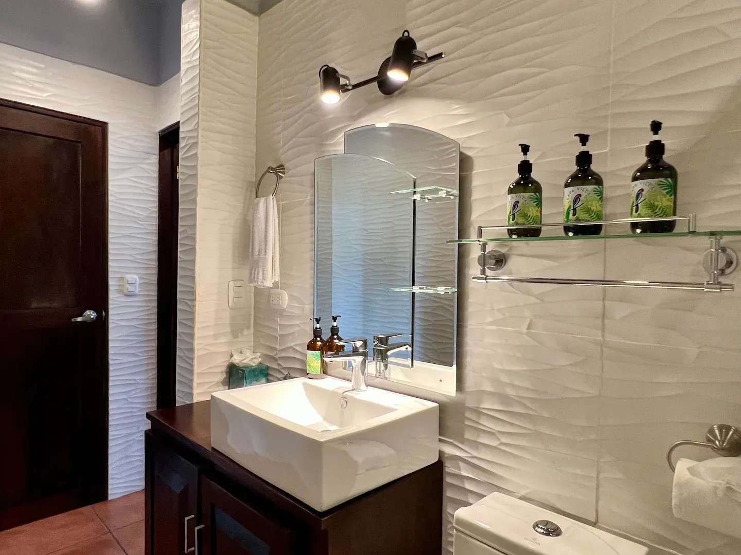 A bathroom with a sink , toilet and mirror.