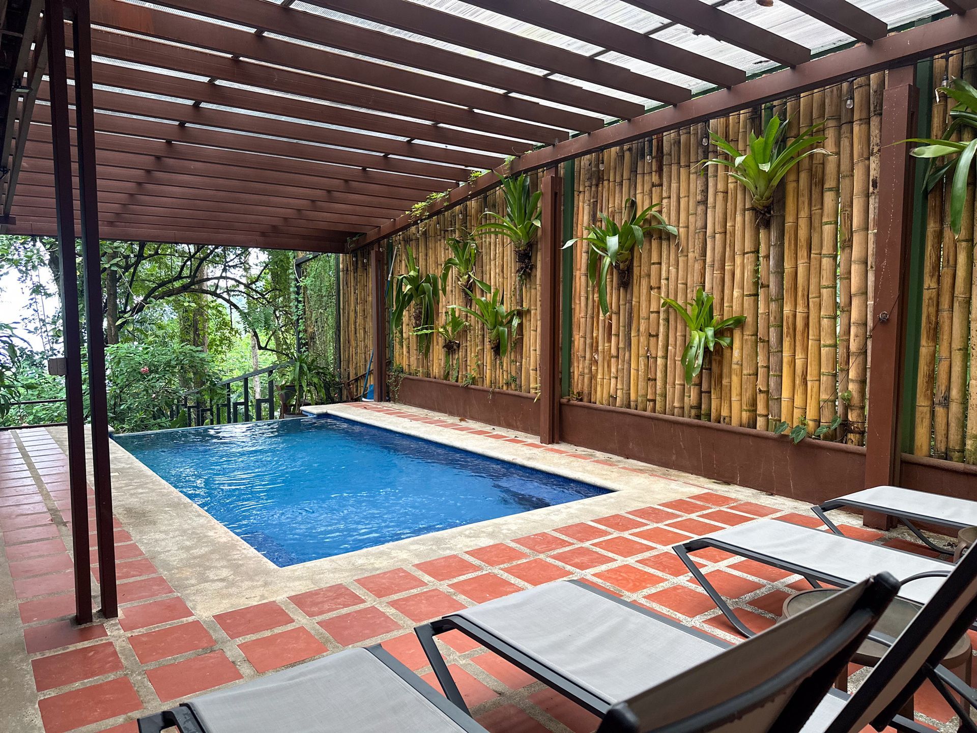 A swimming pool with a pergola and chairs around it