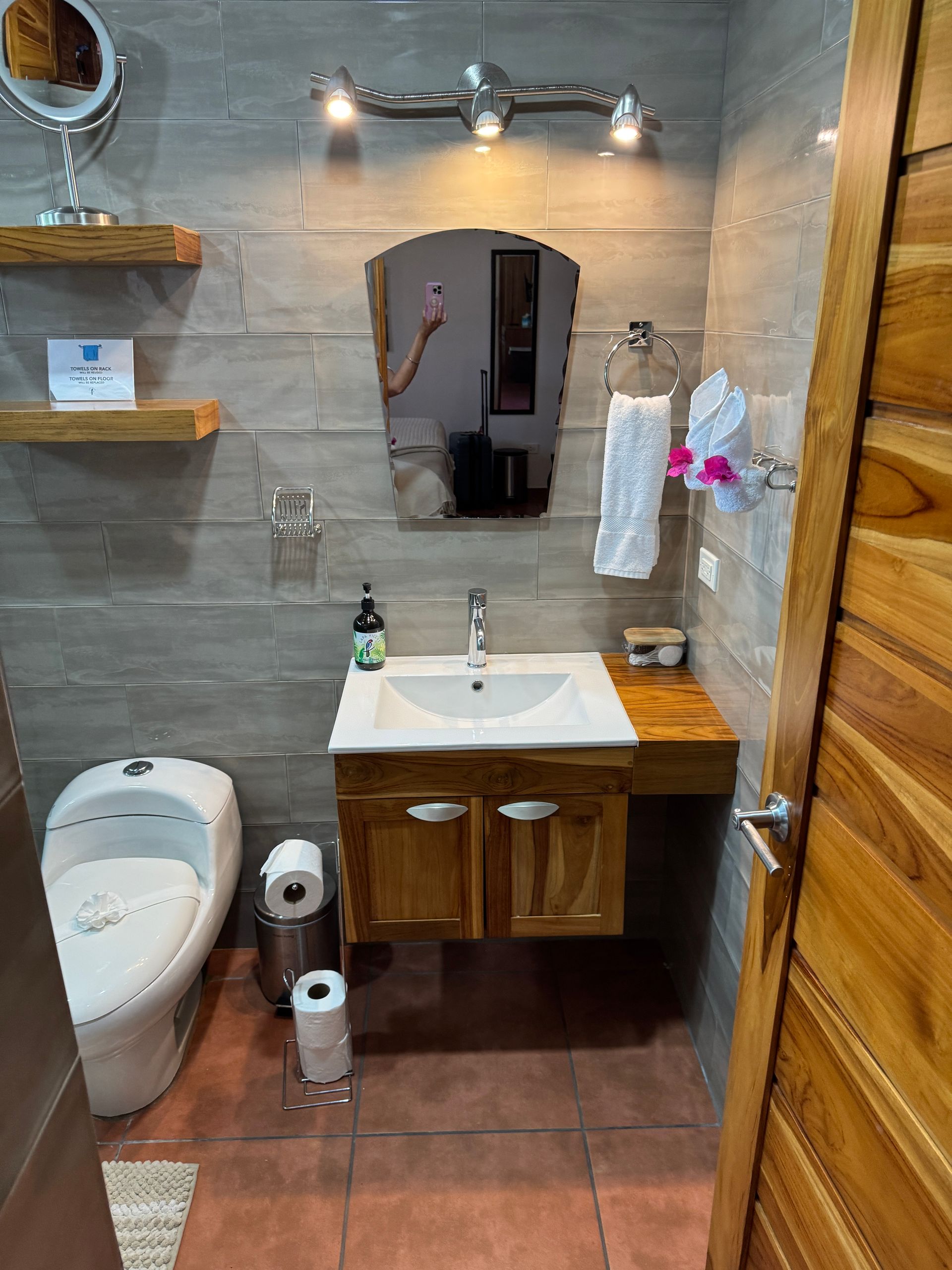 A bathroom with a sink , toilet and mirror.