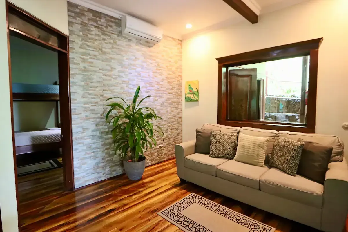 A living room with a couch , bunk beds , and a mirror.