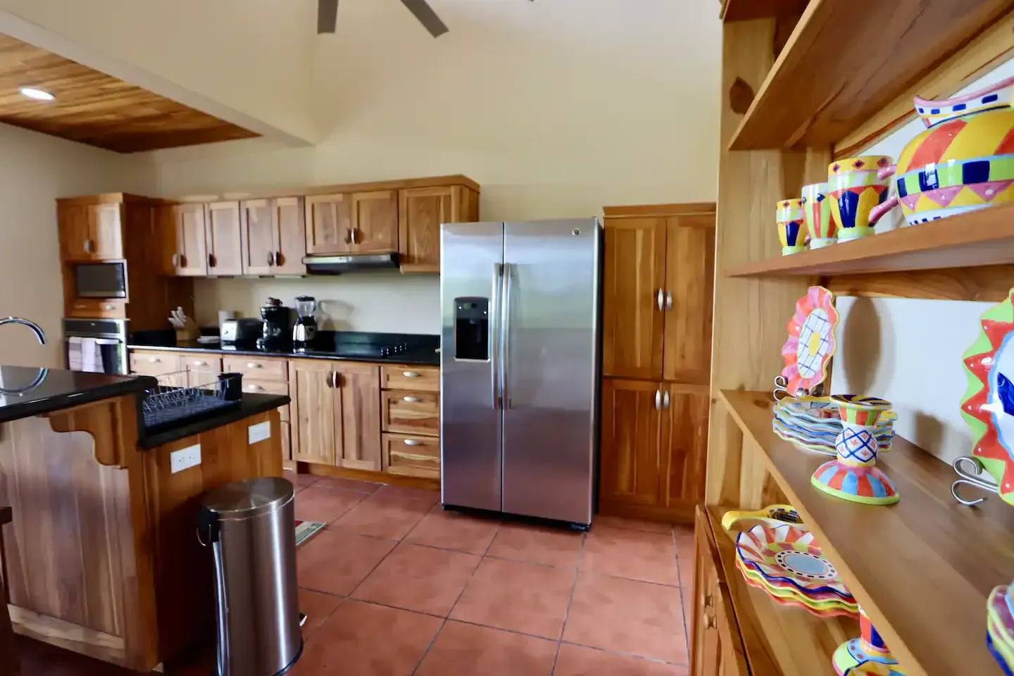 A kitchen with a stainless steel refrigerator and wooden cabinets