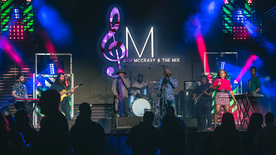 A packed wedding reception with a live band and elegant production