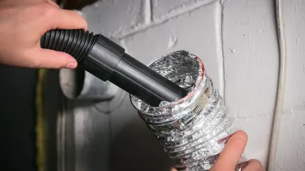A person is using a vacuum cleaner to clean a duct.