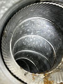 A close up of a metal duct with a hole in the middle.